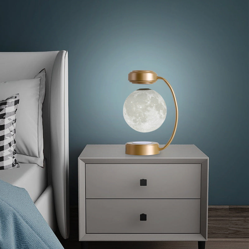 Gold moon LED night light with glowing floating globe on two-level magnetic base