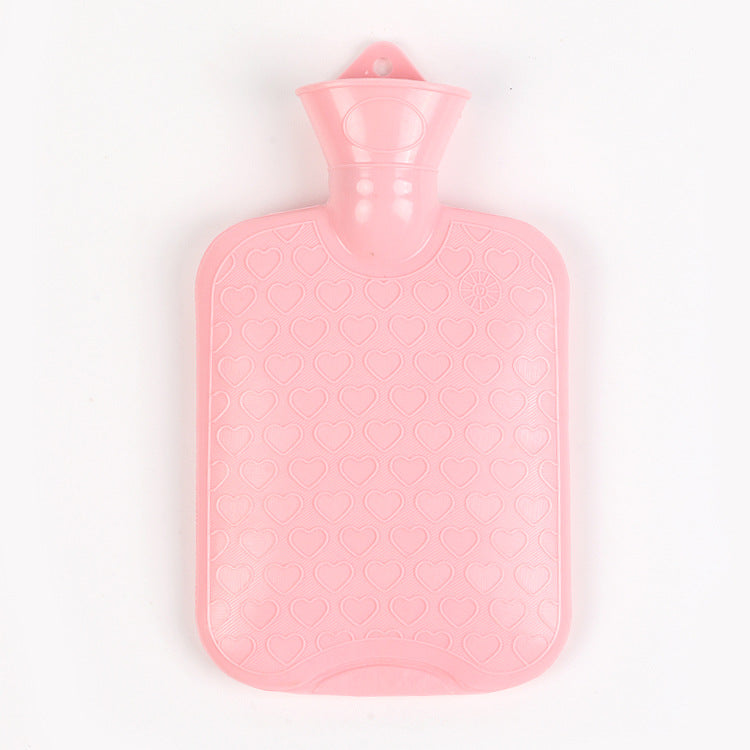 Pink hot water bottle with textured heart pattern and neck stopper