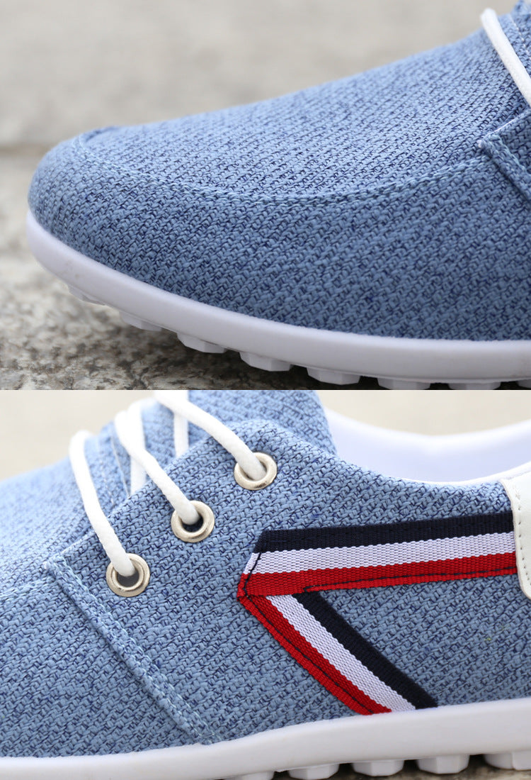 Light blue canvas lace-up shoe with textured upper, tricolor stripe side, white sole