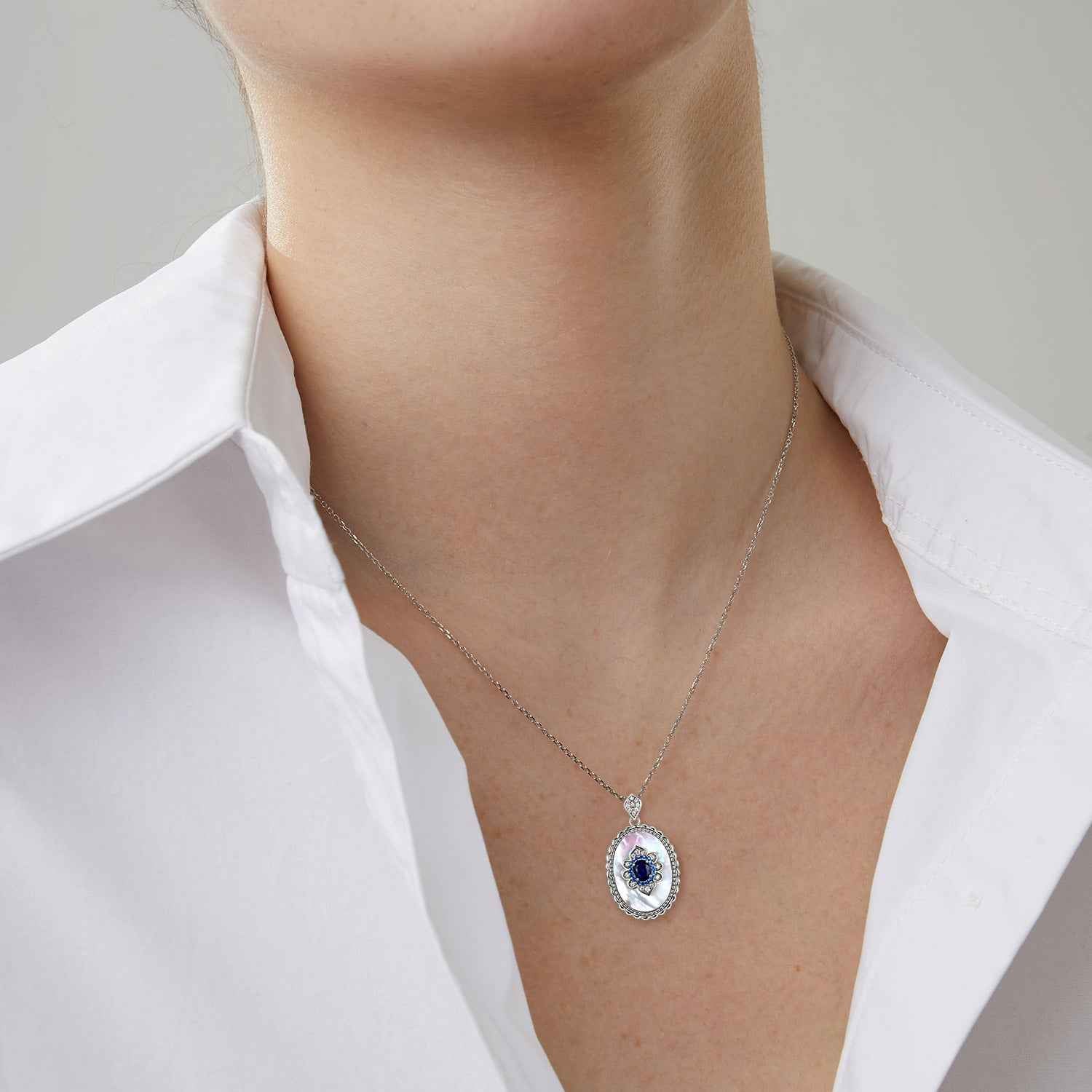 Sterling silver pendant necklace with blue oval charm and small diamond accents