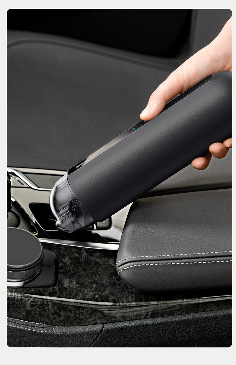 Handheld vacuum cleaner nozzle cleaning a car seat edge and seam.
