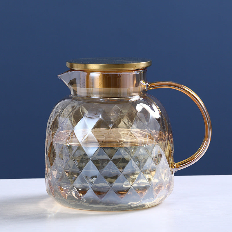 Glass cold water bottle with faceted diamond design, gold-tone top and arched handle