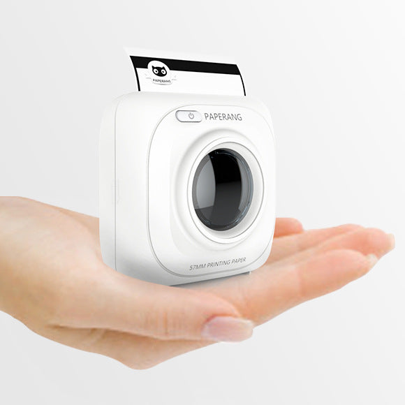 White mini mobile thermal photo printer held in hands, front lens and slot