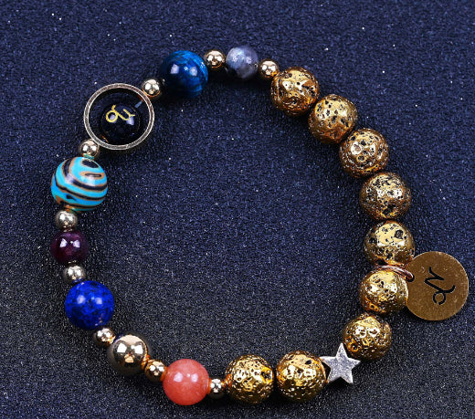 Beaded bracelet with blue, red, and gold beads; round zodiac charm and metallic star.