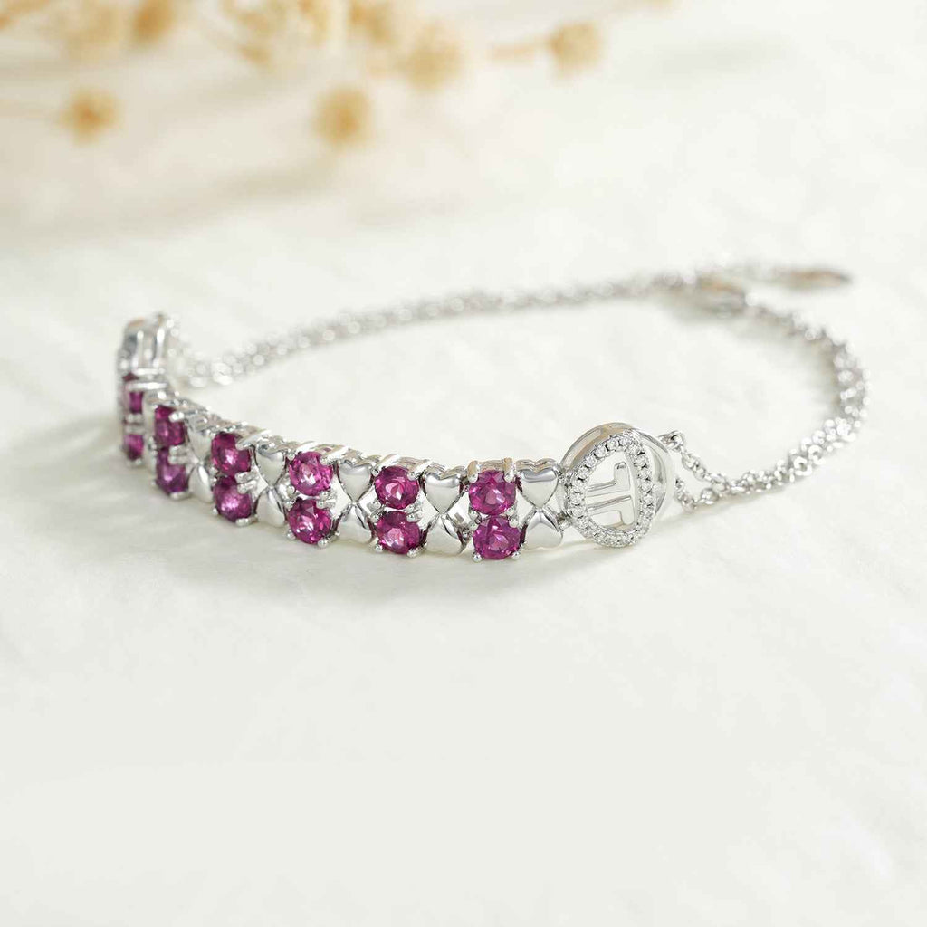 Sterling silver bracelet with purple oval stones in a row and small charm at ends
