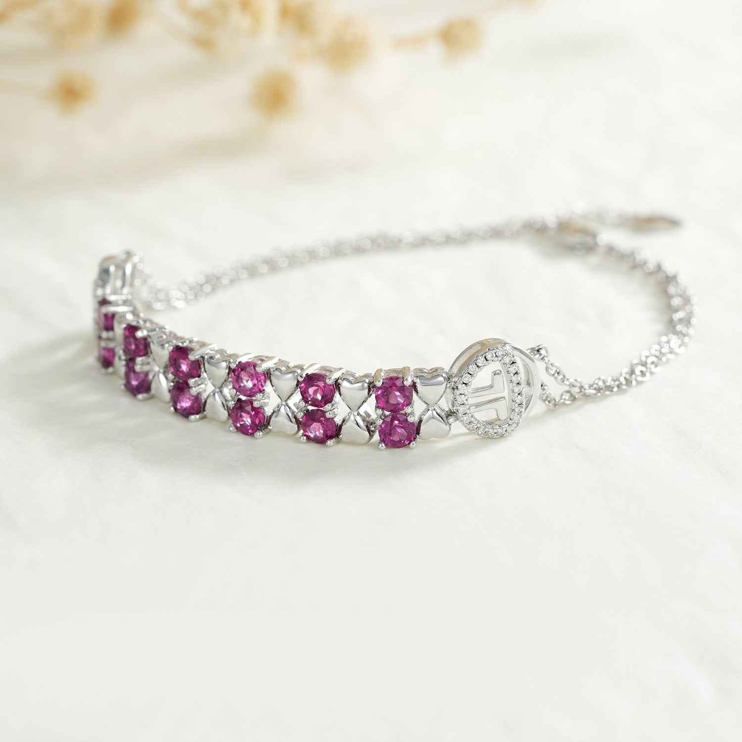Sterling silver bracelet with purple oval stones in a row and small charm at ends