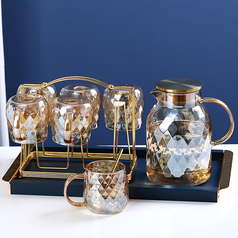 Glass cold water bottle with diamond pattern and three small cups on gold-tone stand