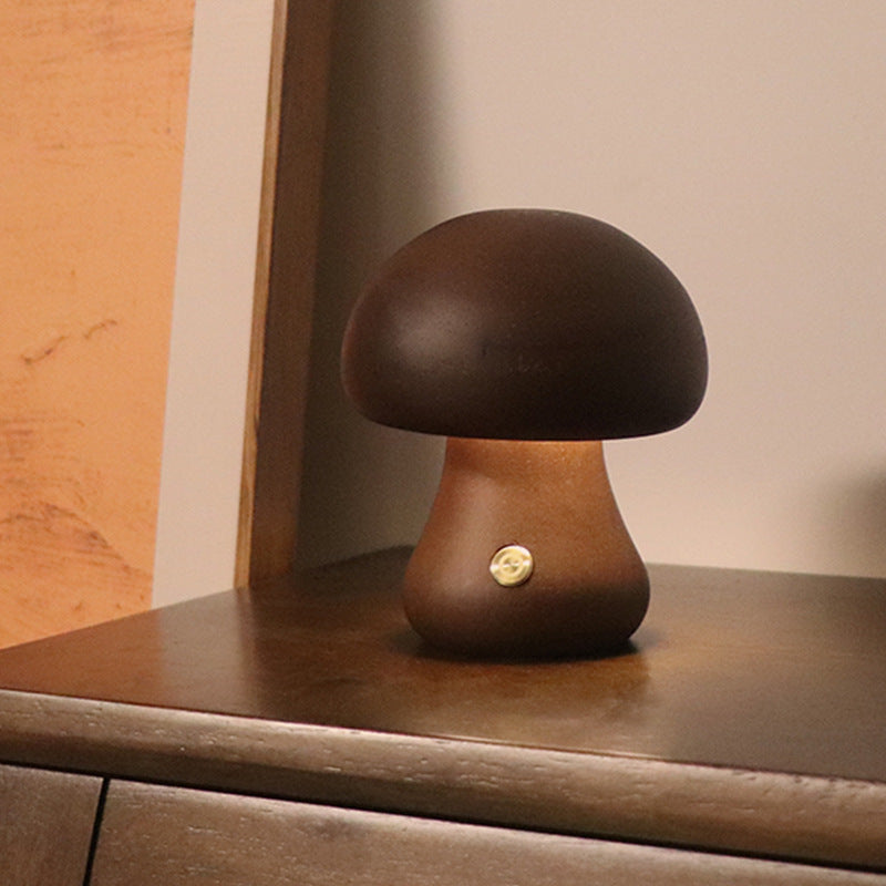 Dark wooden mushroom LED night light with rounded cap, warm glow on shelf