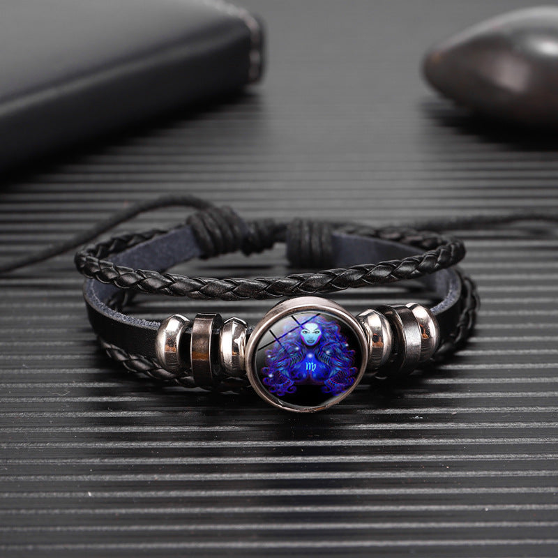 Black braided bracelet with round glowing blue zodiac charm in silver bezel
