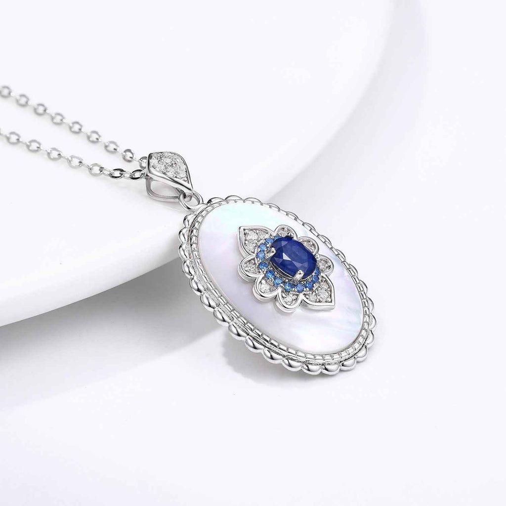 Sterling silver oval pendant necklace with blue sapphire center stone and pavé details