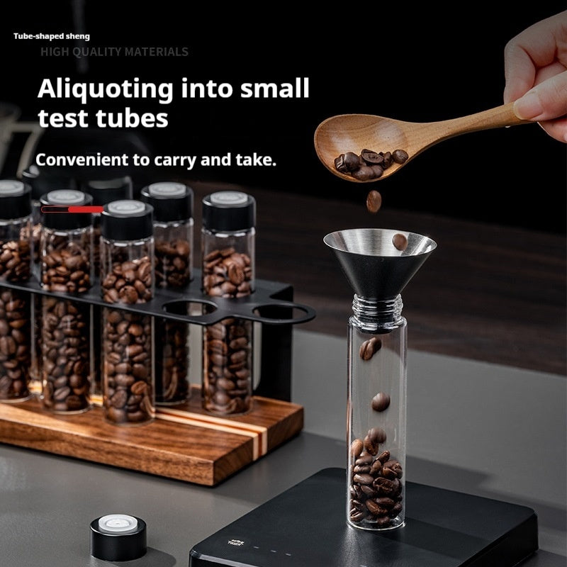 Coffee bean portioning bottle system with clear vials and a metal funnel, beans inside.