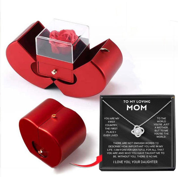 Red jewelry box with clear cover holding a red rose; black gift card included