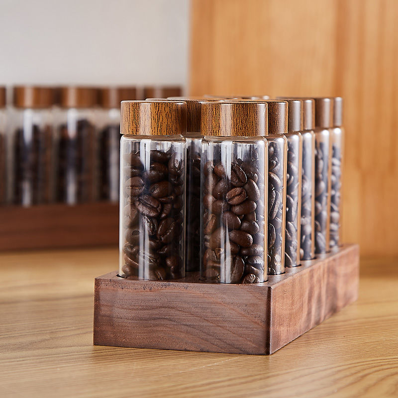 Wooden base holding clear glass bean bottles with bamboo-style caps