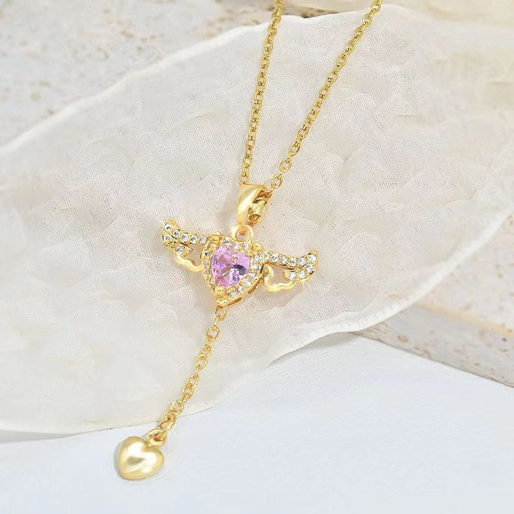 Gold-toned angel wing heart necklace with pink crystal center and small heart drop