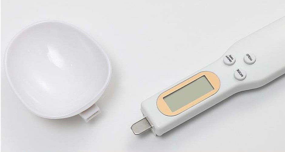 White measuring spoon scale close-up: round spoon and LCD display.