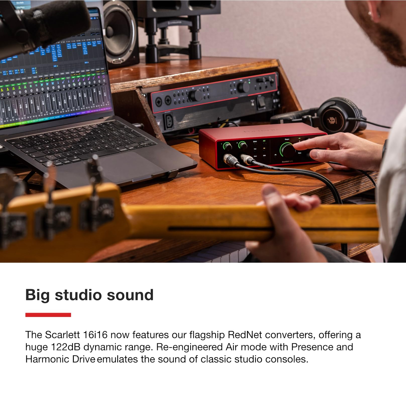 Focusrite Scarlett 18i16 USB audio interface on desk with connected cables and hand adjusting knobs