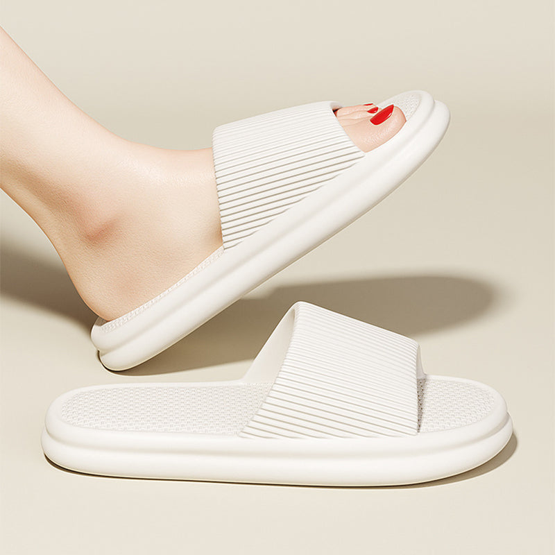 White slip-on home slippers with ribbed strap and cushioned textured footbed
