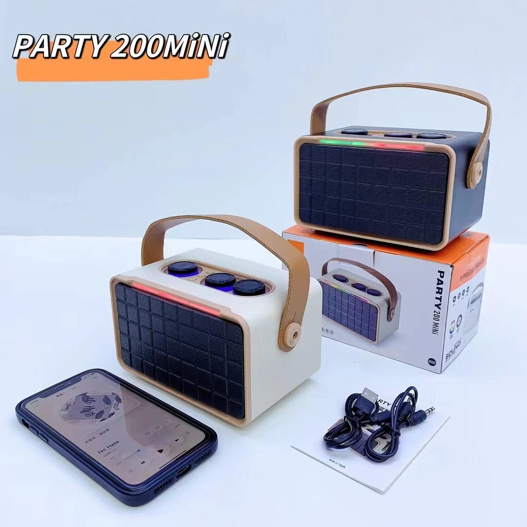 Khaki outdoor Bluetooth speaker with dark grille and RGB bar; charging cables nearby
