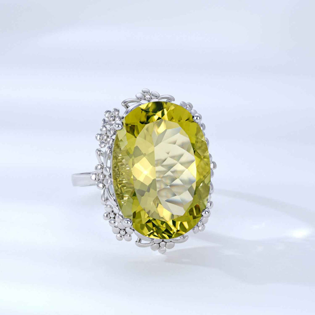 Yellow oval crystal ring with silver filigree side halo and small bead-like prongs