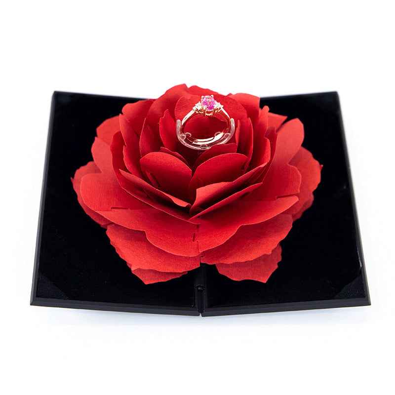 Heart-shaped ring box with large red rose flower and silver ring centerpiece