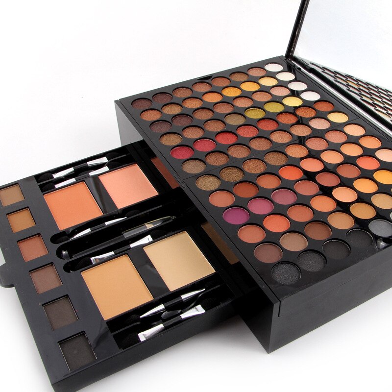 Open piano-shaped eyeshadow palette with multi-color pans and included applicator brushes