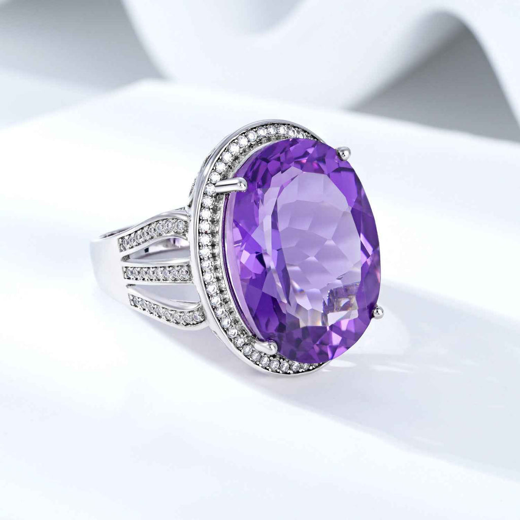 Silver amethyst ring with large oval purple gemstone and diamond-like side accents