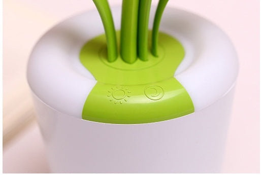LED table lamp with green top insert holding stems; white housing close-up