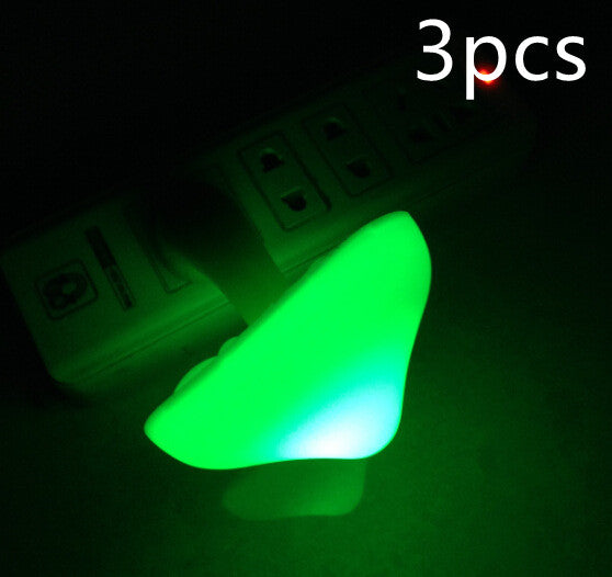 Mushroom night light wall plug lamp with green glowing mushroom head, close view