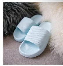 Light blue slide slippers with open toe and cushioned textured footbed.