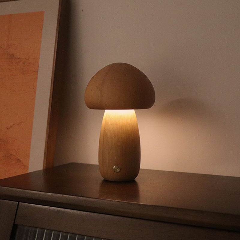 Light wooden mushroom LED night light on a cabinet shelf, warm light glowing