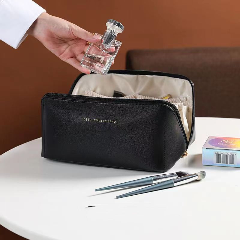 Large travel cosmetic bag in black with zipper top and crossbody strap