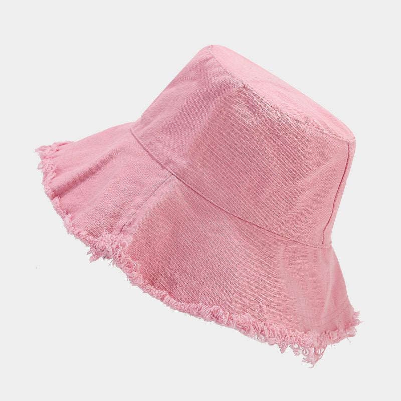 Pink sun hat with wide brim and frayed trim along the edge.