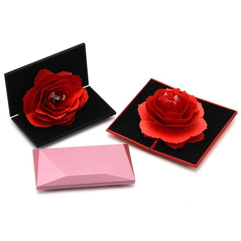 Diamond-shaped ring box with rotating rose, black lid, red rose