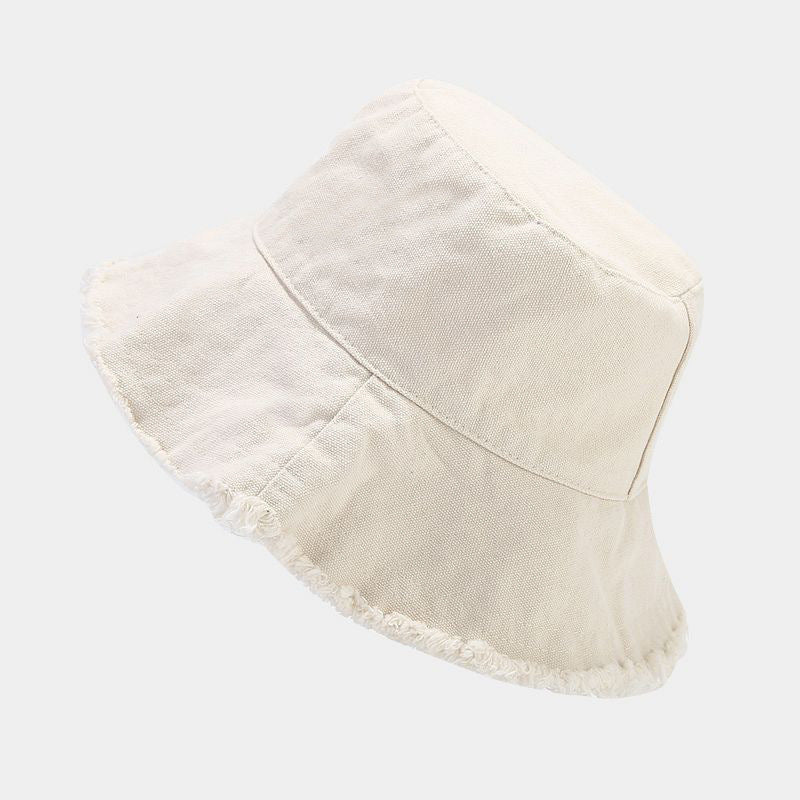 Beige sun hat with wide brim and frayed trim along the lower edge.