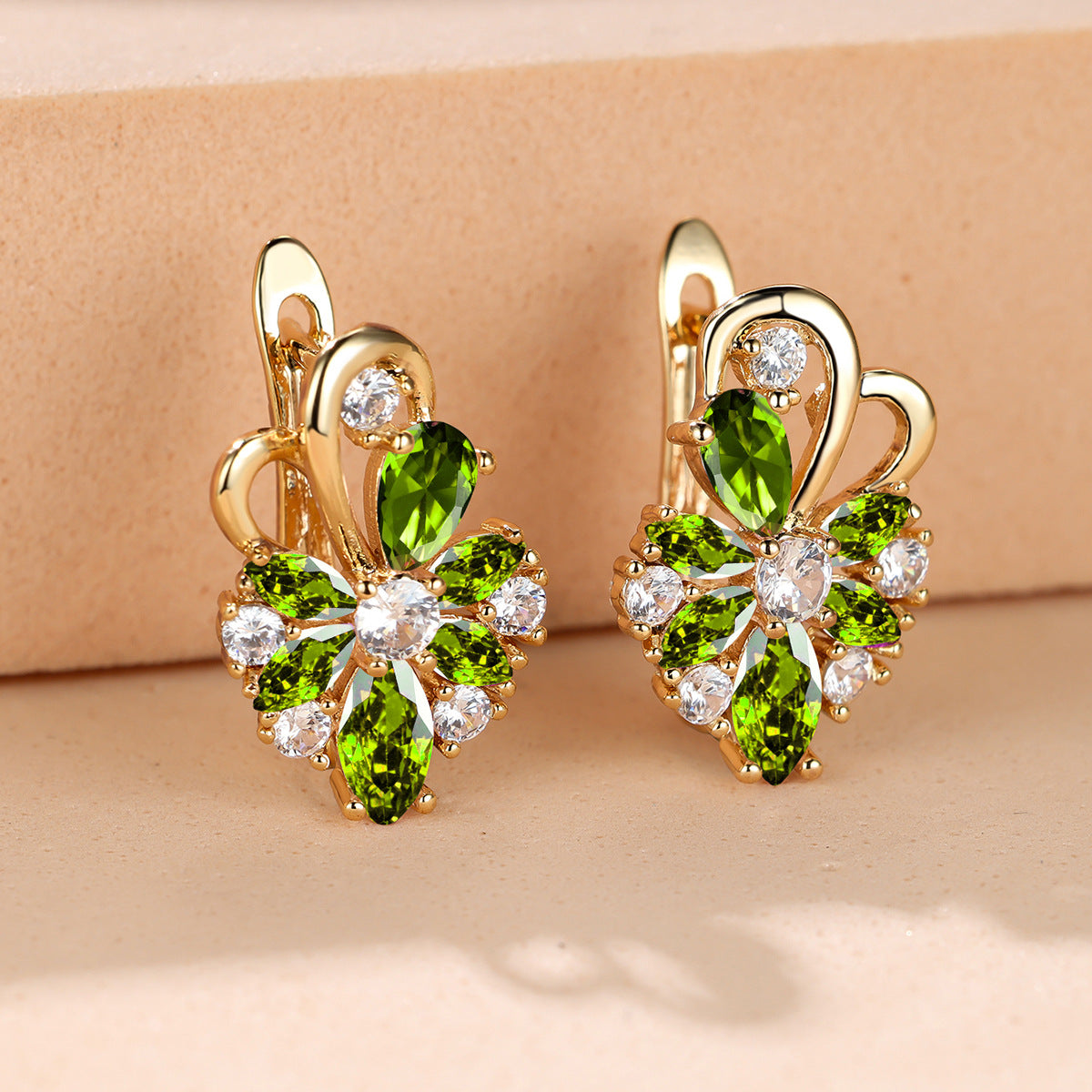 Gold-tone drop earrings with green marquise stones and clear round accents