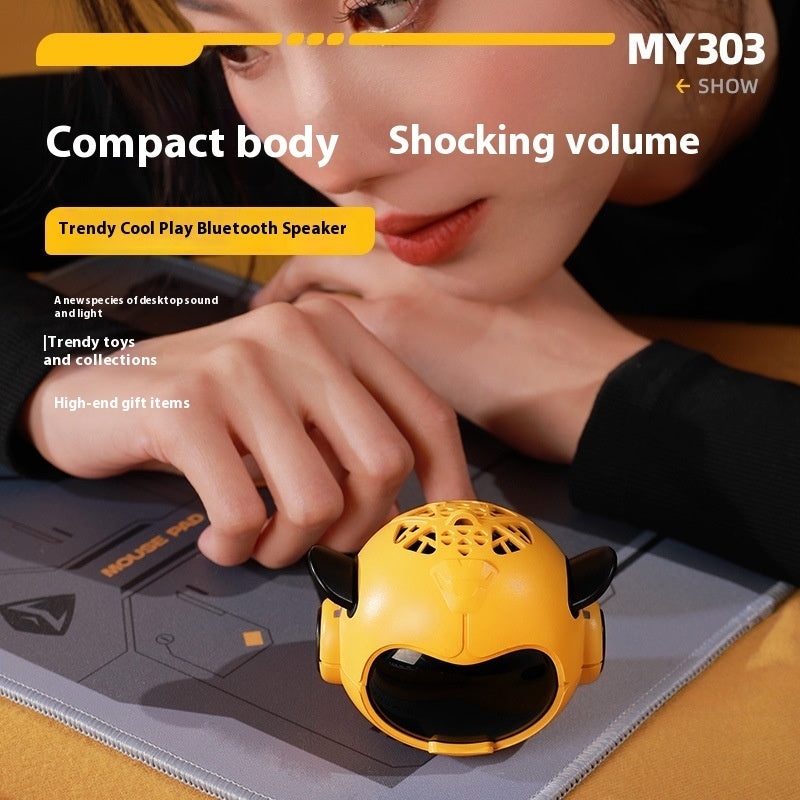 Yellow mini Bluetooth speaker on a mat, with cartoon face and side horn speakers