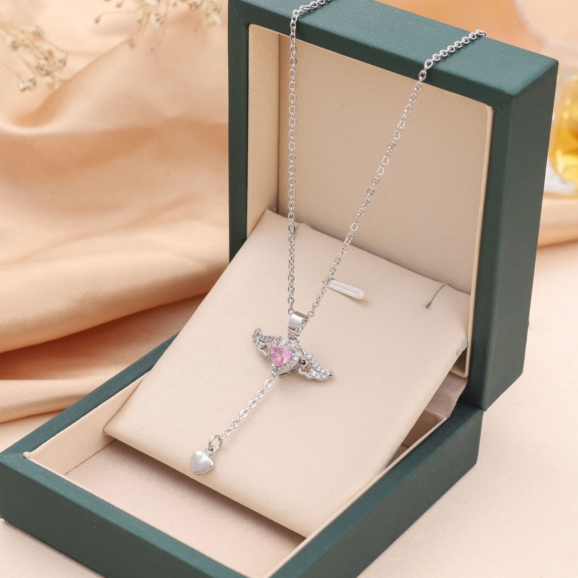 Silver-toned angel wing heart necklace with pink crystal pendant and dangling heart charm