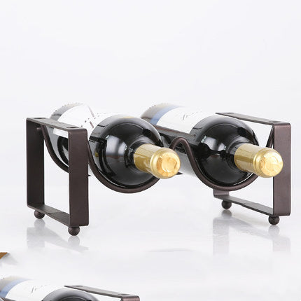 Black metal wine bottle rack with two curved slots, holding two wine bottles