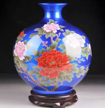 Blue ceramic vase with cream, pink, and red floral motif, glossy black base.